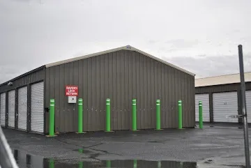 Side of storage building with green poles